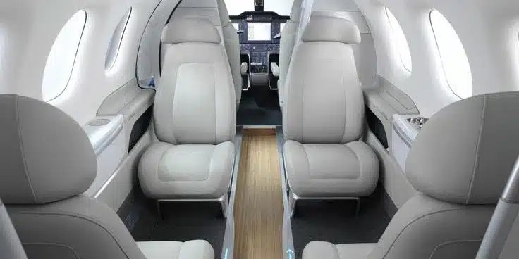 Intérieur jet privé : quatre sièges cuir gris modernes.