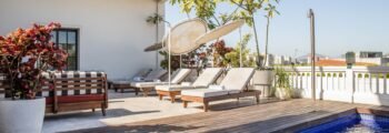Piscine sur le toit avec vue sur la skyline, chaises longues.