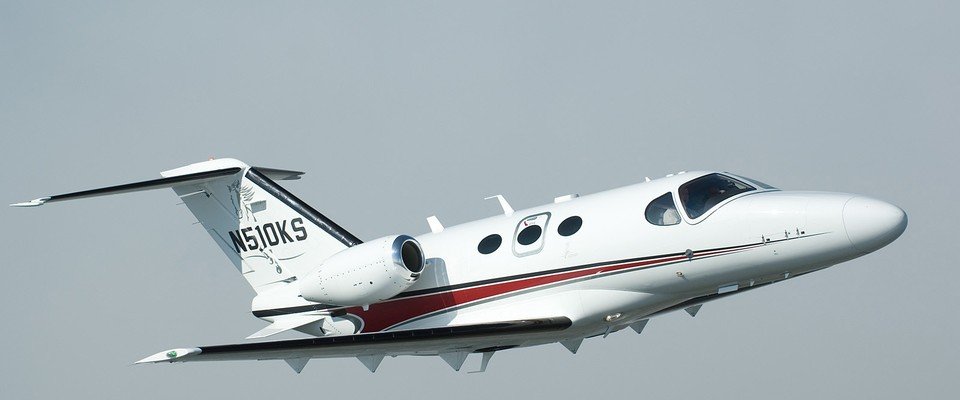 Location de jet privé : petit avion blanc en vol.