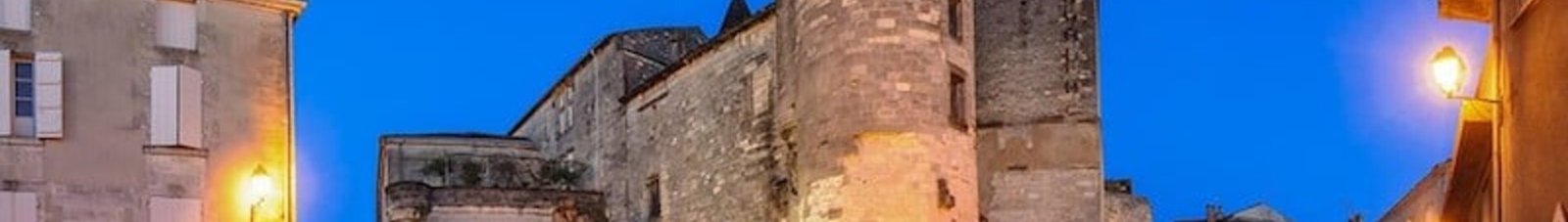 Cognac Châteaubernard fort et tour ronde illuminée au crépuscule.