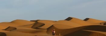 Motocycliste dans le désert près de Dakar, ciel bleu.