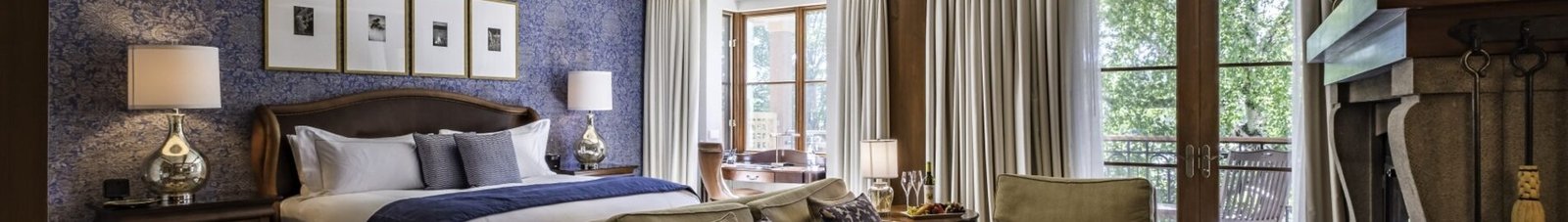 Chambre luxueuse avec cheminée et grande lumière naturelle.