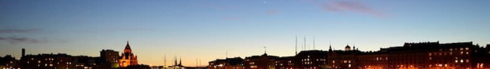 Helsinki crépuscule : Front de mer serein, immeubles illuminés.