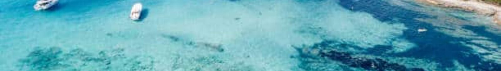 Eau turquoise avec des bateaux, plage en Corse