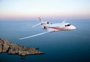 Le jet privé Dassault Falcon 7X qui vole au-dessus de la mer