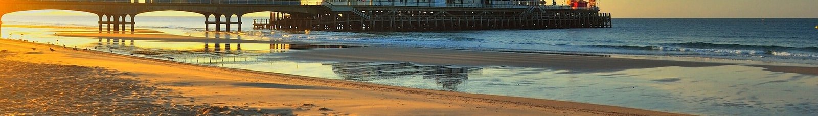 Jetée de Bournemouth au coucher du soleil avec fond d'océan calme.