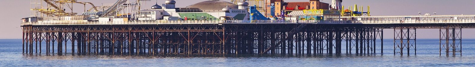 Brighton : jetée, mer calme, ciel dégagé, plage de galets.