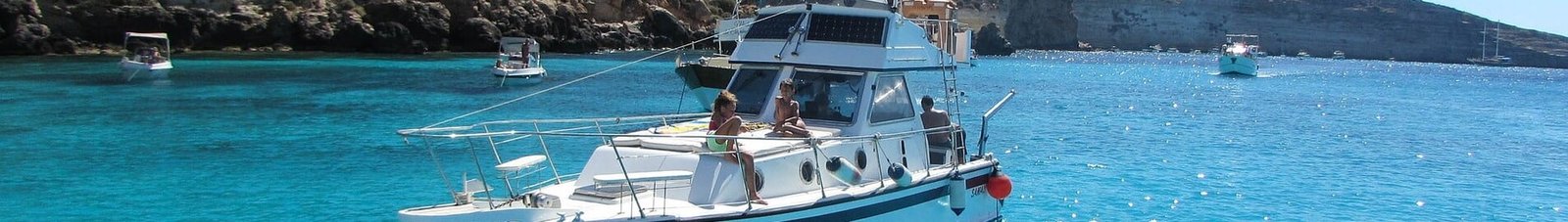 **Location de bateau Lampedusa : Bateau blanc près des falaises**