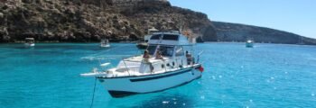 **Location de bateau Lampedusa : Bateau blanc près des falaises**