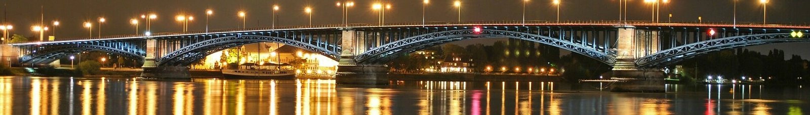 Mayence-Finthen, pont éclairé réfléchissant sur eau calme.
