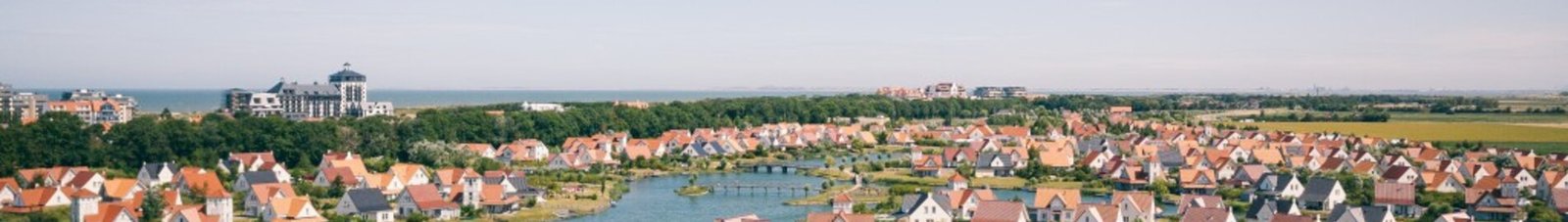 Cadzand quartier résidentiel avec rivière et verdure.