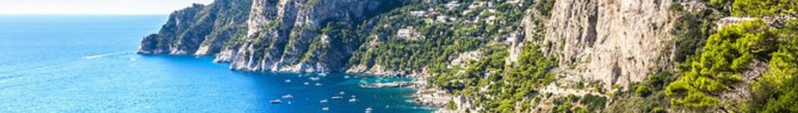 Capri entourée par des bateaux sur mer bleue.