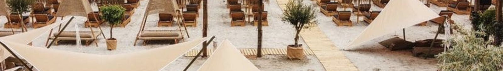 Une plage à Mamaia, des parasols beiges et l'océan.