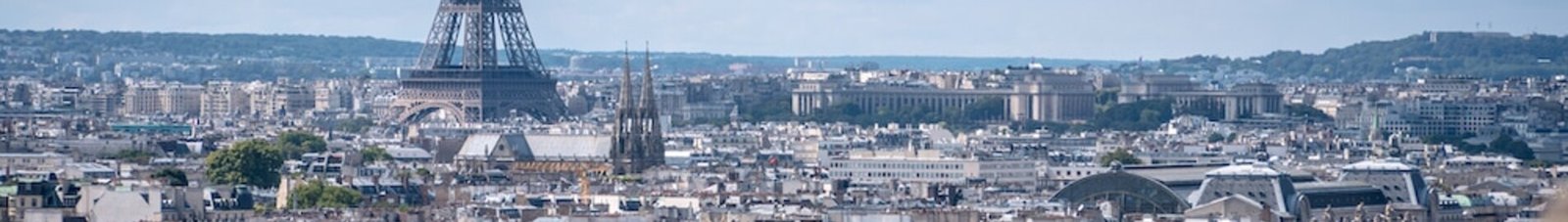 Vue aérienne Paris Seine ponts Tour Eiffel ciel partiellement nuageux.